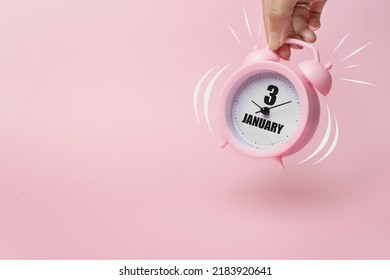 January 3rd. Day 3 of month, Calendar date. The morning alarm clock jumping up from the bell with calendar date on a pink background.  Winter month, day of the year concept