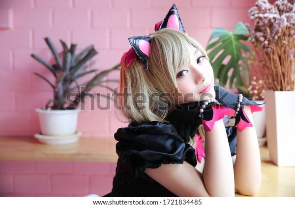 Japan anime cosplay , portrait of girl cosplay\
in pink room background