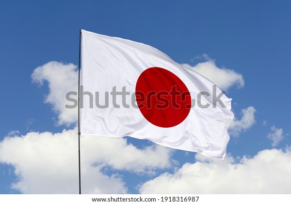 Japan flag isolated\
on the blue sky with clipping path. close up waving flag of Japan.\
flag symbols of Japan.