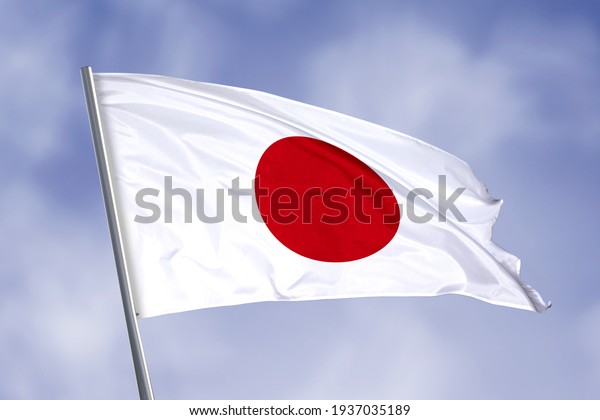 Japan flag isolated on sky\
background. close up waving flag of Japan. flag symbols of\
Japan.