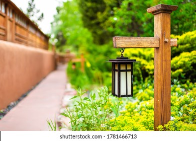 Japan Hanging Lantern Lamp Light On Wooden Post In Japanese Garden With Path By House Temple And Green Foliage Background