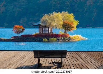 Japan Kawaguchiko. Bench on wooden pier. Bench overlooking traditional Japanese gazebo. Place for meditation. Landmarks of Japan. Lake Kawaguchiko with autumn trees. Japan tourism. Asian landscape