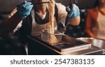 Japan, restaurant and hands cooking noodles for traditional cuisine, culinary culture and meal preparation. People, gloves and steaming ramen with chopsticks for nutrition, lunch and healthy dinner