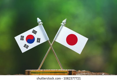 Japan And South Korea Small Flag With Blur Green Background