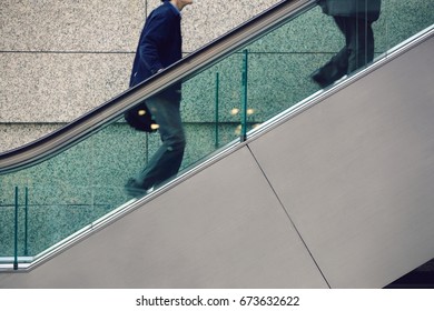 Japan, Tokyo, Tokyo International Forum, two men ascending escalator, mid section - Powered by Shutterstock