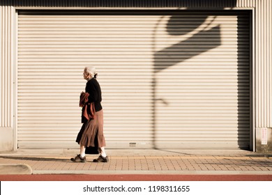 JAPAN, TOKYO - NOVEMBER 2016: An Unidentified Old Woman Walks Along The Roadside Of Tokyo, Japan. Japan's Population Is Aging.