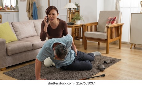 Japanese Adult Daughter Running Into Living Room To Help Her Retired Dad And Calling Ambulance With Smartphone. Elder Senior Person Slip And Fall Risk At Home Concept