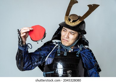 Japanese armed samurai who is troubled watching a wallet. - Shutterstock ID 2045328080