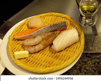 Japanese Assorted Fancy Seafood Dinner Set With Fresh Raw Salmon Steak, Shrimps, Scallop And Squid With Butter On Wicker Tray On Restaurant Table