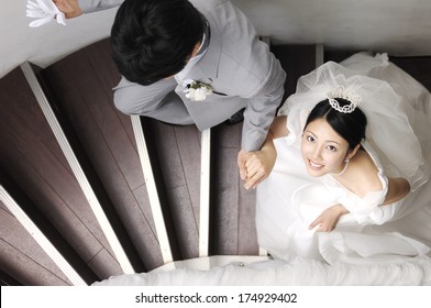 Japanese bride and groom climbing the staircase