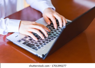 Japanese Business Person Typing Laptop Computer At Home