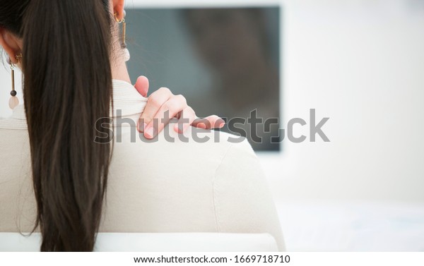 Japanese business woman\
holding shoulder