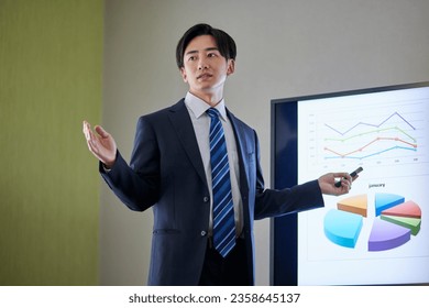 Japanese businessman wearing a suit giving a presentation - Powered by Shutterstock