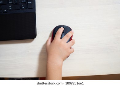 A Japanese Child Operating A Mouse On A Computer