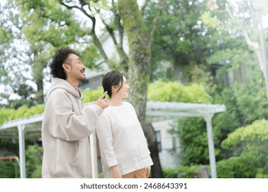 A Japanese couple gazing into the distance in a fresh green park. Gazing into the future and hope. - Powered by Shutterstock