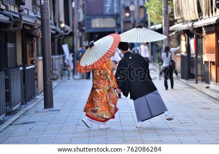 
A japanese couple on their wedding day dressed up in traditional kimono taking photo shots in kyoto