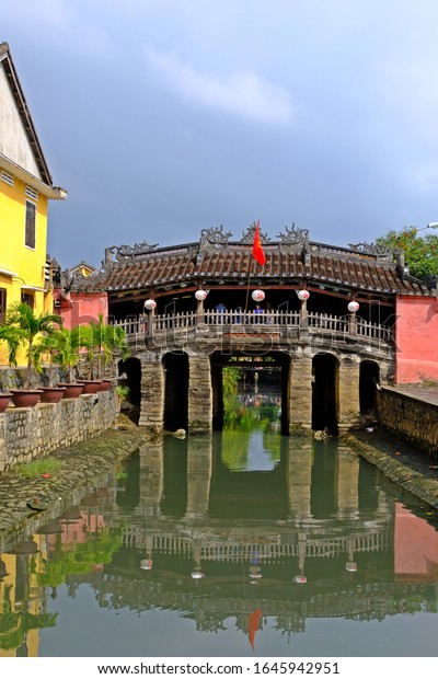 Japanese Covered Bridge, favorite spot in Hoi An\
is the elegant pink Japanese Bridge built to divide the city during\
the Japanese occupation, While it was once a symbol of separation,\
Hoi An, VIETNAM.
