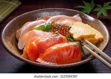 Japanese donburi rice bowl with caviar, salmon meat, scrambled eggs and leaf on a plate, traditional Asian food 