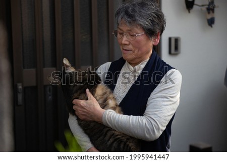 A Japanese elderly lady holding her cute cat