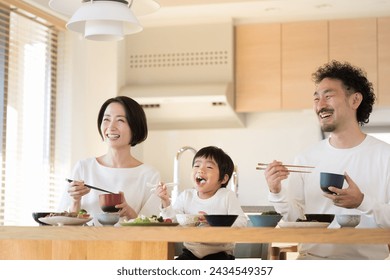 A Japanese family eating dinner or lunch together on good terms. Father, mother, and young son. - Powered by Shutterstock