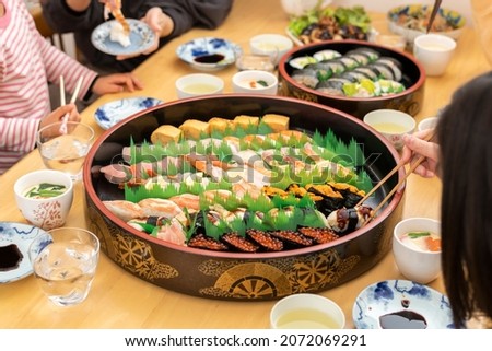 A Japanese family having a sushi party with their family.