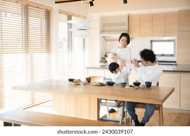 Japanese family in the living room. Father, mother, boy and baby. Enjoyable meals in the morning and afternoon. - Powered by Shutterstock