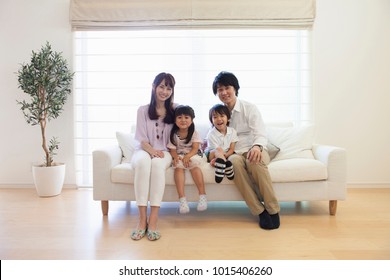 Japanese family sitting on the sofa - Shutterstock ID 1015406260