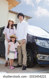 Japanese Family Standing In Front Of Car