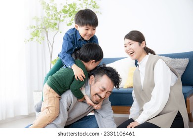 Japanese father playing with his children in the living room on a holiday - Powered by Shutterstock