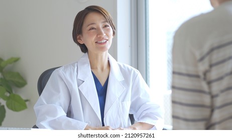 Japanese female medical worker examining a patient - Shutterstock ID 2120957261