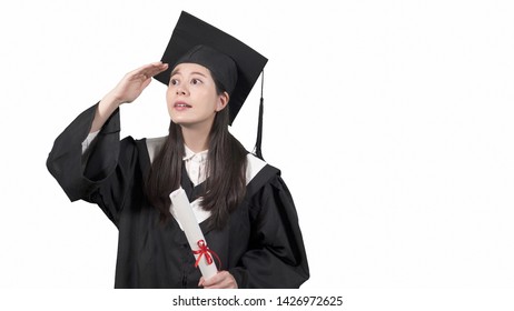 Japanese Female New Society Of Smile Looking Aside With White Background. Young College Girl Fresh Graduate In Gown And Cap Searching Job With Hand Gesture On Forehead Eyes Full Of Hope Future Trend.