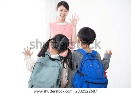 A Japanese female teacher seeing a child off. Situations at school, cram school, and lessons.