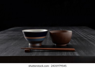 Japanese food background, black dining table with bowls and chopsticks - Powered by Shutterstock