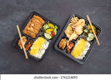 Japanese food bento set with tonkatsu and tempura on dark stone background