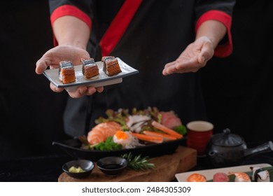 Japanese food chef gestures to invite you to eat Unagi Eel Nigiri Sushi (eel sushi), Japanese food in his hand., selective focus - Powered by Shutterstock