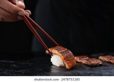 Japanese food chef prepare to Unagi Eel Nigiri Sushi (Eel Sushi) Japanese food style on black stone plate, selective focus - Powered by Shutterstock