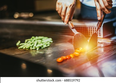 Japanese food counter,Japanese teppan dining,A-LA-CART,Hand of man take cooking of meat with vegetable grill,Chef cooking wagyu beef in Japanese teppanyaki restaurant