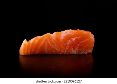 japanese food an isolated piece of salmon sashimi close up macro photo on black background from the front - Powered by Shutterstock