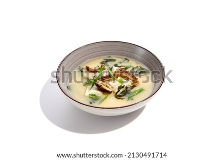 Japanese food - miso soup with tofu, wakame and shiitake mushroom. Vegetarian miso soup in ceramic bowl on isolated white background