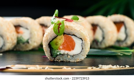 Japanese food. Roll with salmon, vegetables and cottage cheese. Maki sushi rolls with salmon, cream cheese, avocado, sesame seeds and nori.