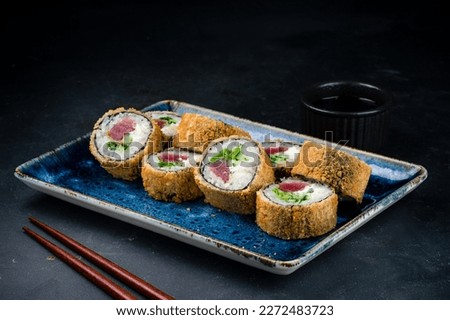 Japanese food rolls with fish, vegetables and cottage cheese. Set of tempura sushi rolls with tuna, cream cheese, cucumber and lettuce.