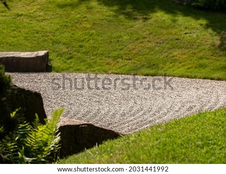 Japanese Garden with raked gray gravel framed by gras.