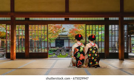 Japanese Geisha Look At A Small Rock Garden At  Kennin-ji Temple In Colorful Autumn