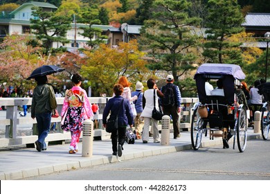 Japanese girl with beautiful kimino at Arashiyama bridge to enjoy cherry blossom, Hanami, in Kyoto, Japan