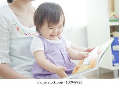 Japanese Girl Reading A Picture Book To Her Mother,