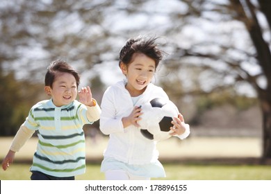 Japanese girl running with a soccer ball