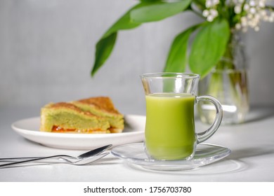 Japanese Green Tea Matcha With Coconut Milk And Frangipane Tart With Almond, Te Matcha And Apricot Jam. Grey Background.