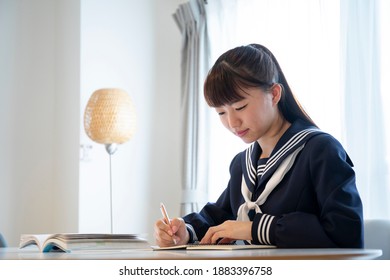 Japanese high school girl studying online in the living room