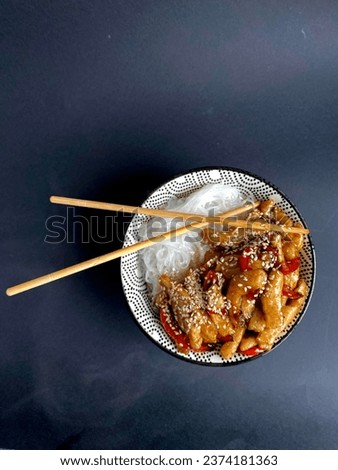 Japanese hot dish bowl chicken teriyaki spicy rice noodles wok sesame wooden sticks black background food steam diet healthy food carbohydrates and protein proper nutrition