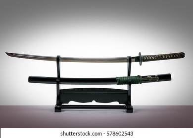 Japanese iaido sword in black wooden stand and white background. Still life studio shot with center light. 